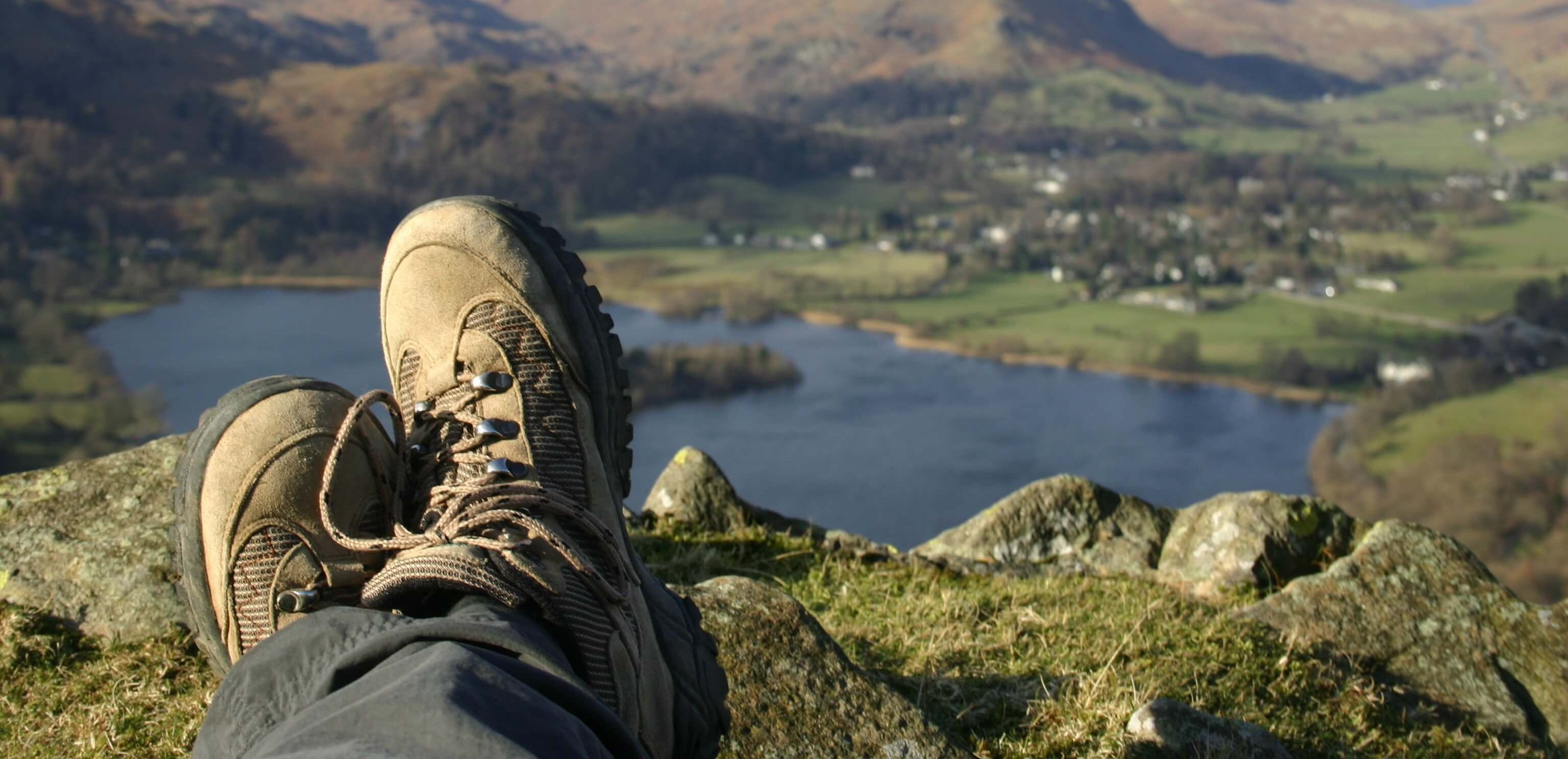 Hiker resting at the top of a hill in the Lake District