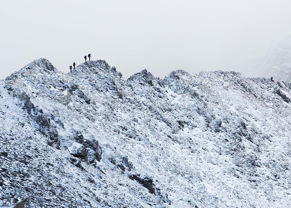 4 Ice Climbers making their way across Striding Edge in the Lake District. Winter hiking