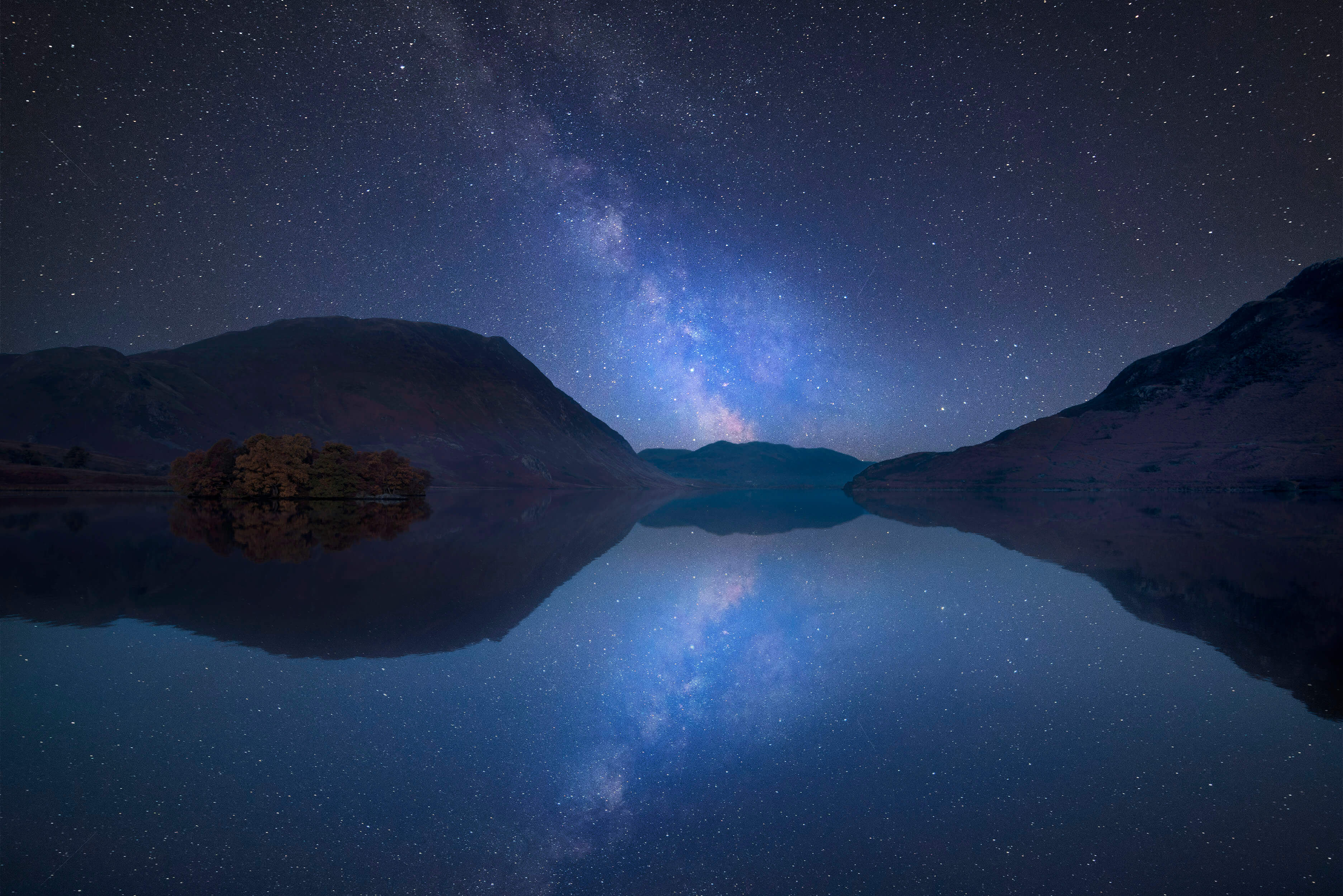 Vibrant Milky Way composite image over landscape of Crummock Water in Lake District England