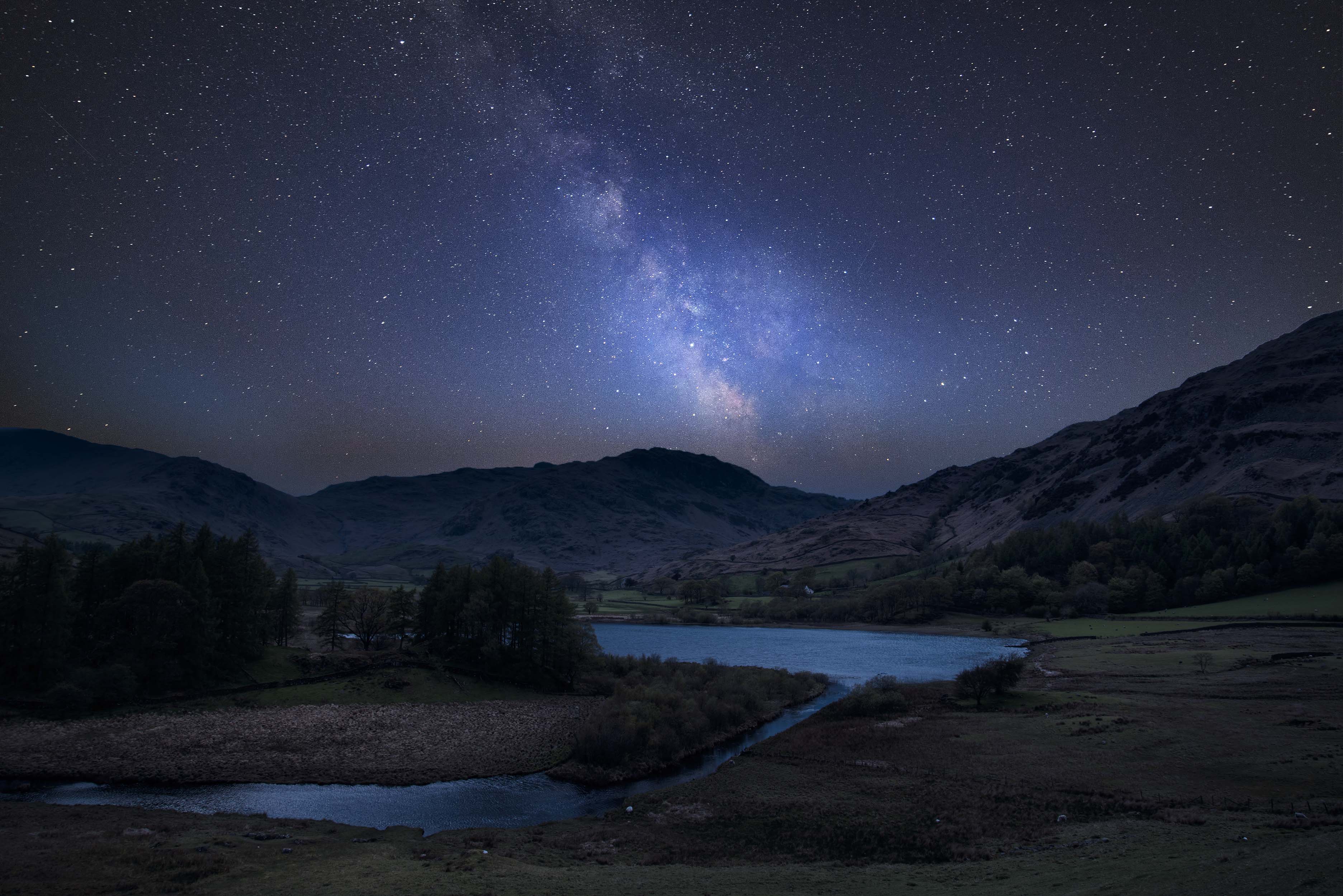 Stunning vibrant Milky Way composite image over landscape of Lake District landscape in England